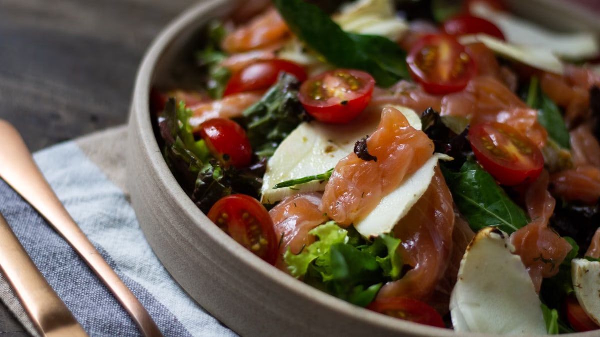 A vibrant salad featuring cherry tomatoes, cheese slices, and fresh greens.